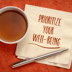 Prioritize Your Well-Being written on a napkin next to a cup of tea